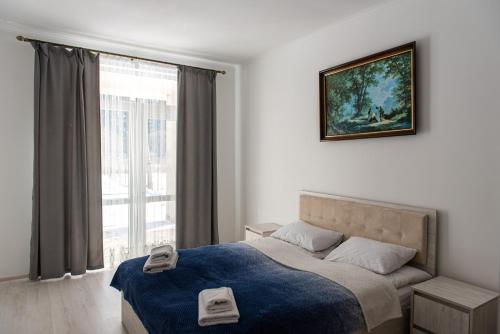 una camera da letto con un letto con una coperta blu e una finestra di Zarinok House a Skole