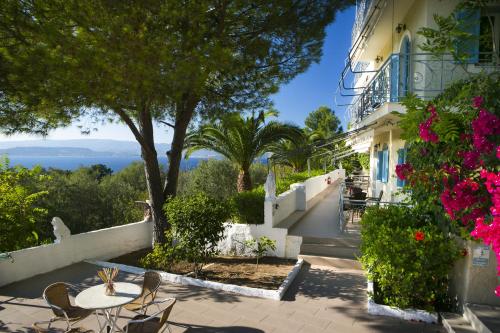 a house with a table and chairs and flowers at Irini Apartment in Lassi