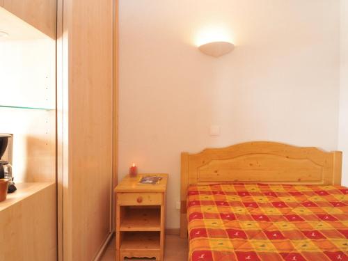 une petite chambre avec un lit et une table de chevet dans l'établissement Appartement rénové skis aux pieds avec balcon - FR-1-181-2050, à La Plagne Tarentaise