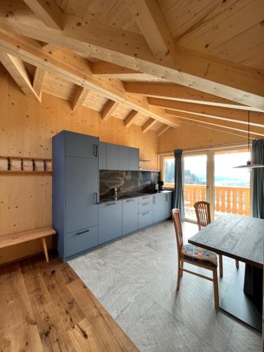 uma cozinha com tectos em madeira e uma mesa e cadeiras em Bio Felderhof em Villa Ottone