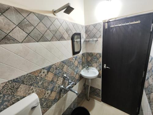 La salle de bains est pourvue d'un lavabo et de toilettes. dans l'établissement Stylish 2BHK Service Apartment Near Golpark, à Kolkata