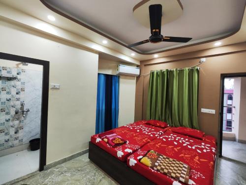 - une chambre avec un lit rouge et un ventilateur de plafond dans l'établissement Stylish 2BHK Service Apartment Near Golpark, à Kolkata