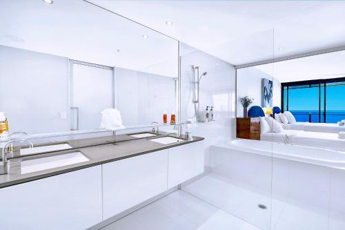 a white bathroom with two sinks and a tub at Circle On Cavill Surfers Paradise Apartments-Holiday Paradise in Gold Coast