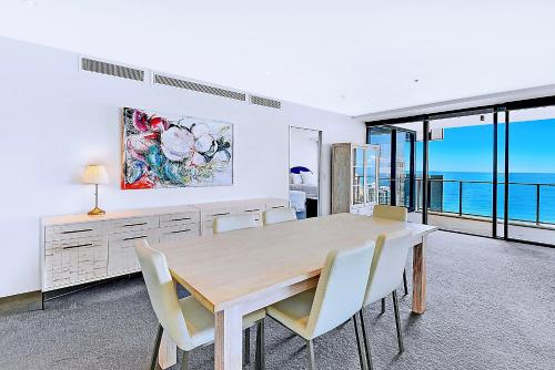 a dining room with a wooden table and chairs at Circle On Cavill Surfers Paradise Apartments-Holiday Paradise in Gold Coast