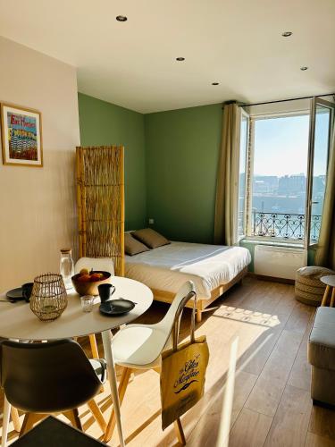 - une chambre avec un lit et une table ainsi qu'une chambre avec vue dans l'établissement La Paillote Dieppoise vue port exceptionnelle 2 à 4 pers, à Dieppe