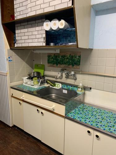 a kitchen with a sink and a counter top at 山下ホテル301 in Kurosakimachi