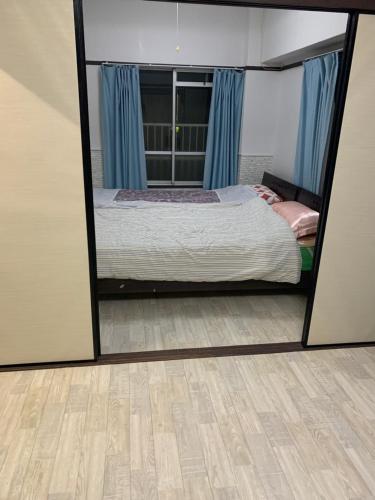 1 dormitorio con cama y espejo grande en 山下ホテル301, en Kurosakimachi
