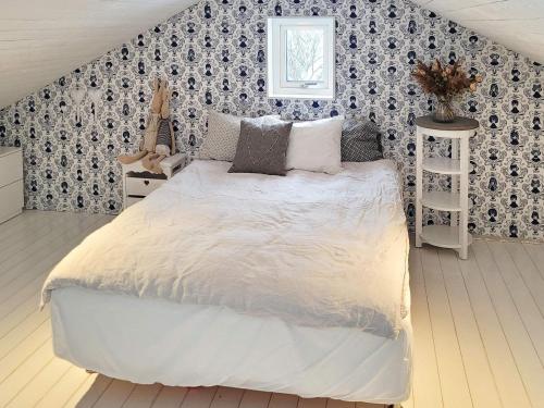 1 dormitorio con 1 cama blanca grande y pared en Holiday home ELLÖS IX, en Ellös