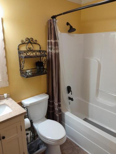 uma casa de banho com um WC, um lavatório e um chuveiro em Chateau DeVille of West Shreveport em Greenwood