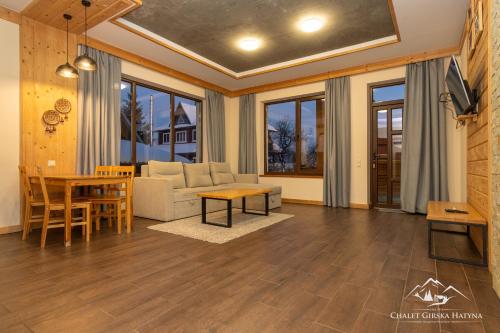 a living room with a couch and a table at Apartments Chalet Girska Hatyna in Vorokhta
