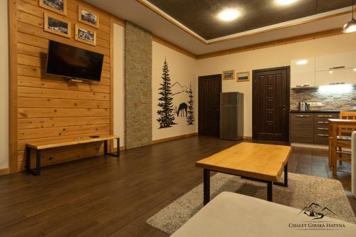 a living room with a flat screen tv on a wall at Apartments Chalet Girska Hatyna in Vorokhta