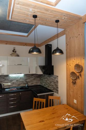 a kitchen with two lights hanging from the ceiling at Apartments Chalet Girska Hatyna in Vorokhta
