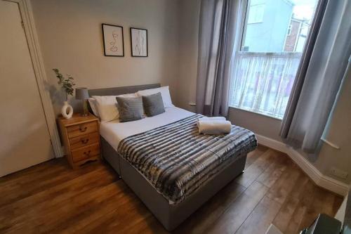 een slaapkamer met een bed en een raam bij Entire House Near City Centre with Parking Permit (3 bedrooms, Sleeps 8) in Liverpool