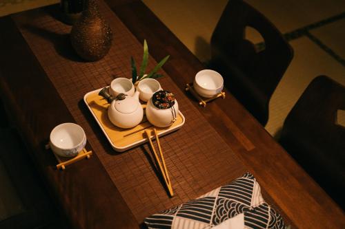 a table with a tray with three tea cups on it at HISASHI 池下 in Nagoya