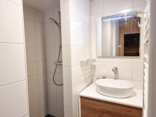 een witte badkamer met een wastafel en een douche bij Vakantiewoning Lux Dune Oostkapelle OK47 in Oostkapelle