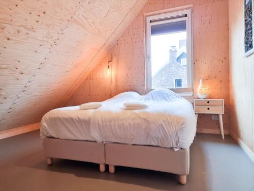 een slaapkamer met een bed en een raam bij Vakantiewoning Lux Dune Oostkapelle OK47 in Oostkapelle