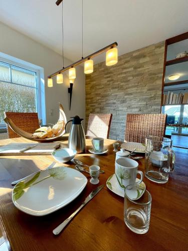 a wooden table with plates and cups on top of it at Ferienwohnung Magma in Lutzerath