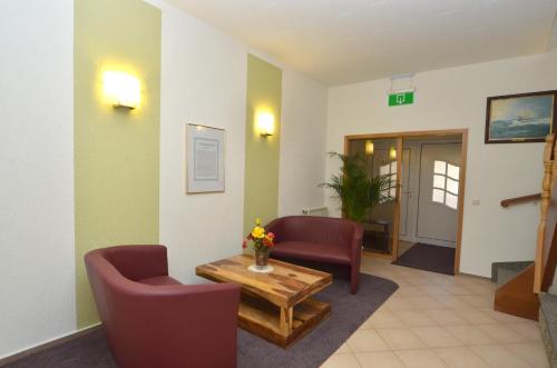 a living room with two chairs and a table at Land-Hotel Am Wald Garni in Greiz