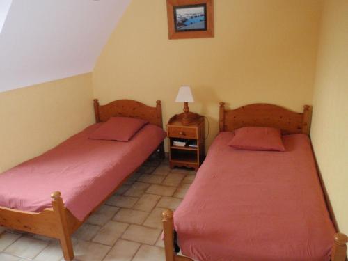 1 dormitorio con 2 camas y mesa con lámpara en 20 Résidence de Kerlosquen en Fouesnant