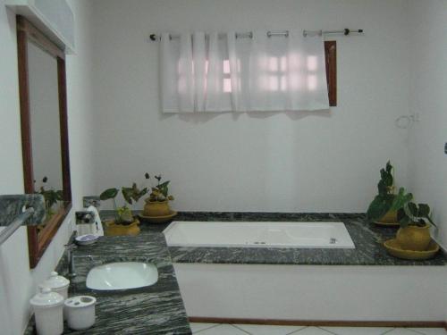 a bathroom with a bath tub and a sink at Hotel e Pousada Canoa Quebrada in Canoa Quebrada