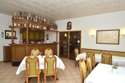 a restaurant with two tables and chairs and a counter at Land-Hotel Am Wald Garni in Greiz
