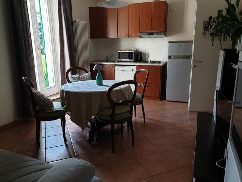 a kitchen with a table and chairs and a kitchen with a refrigerator at Caffè del Viaggiatore in Valsolda