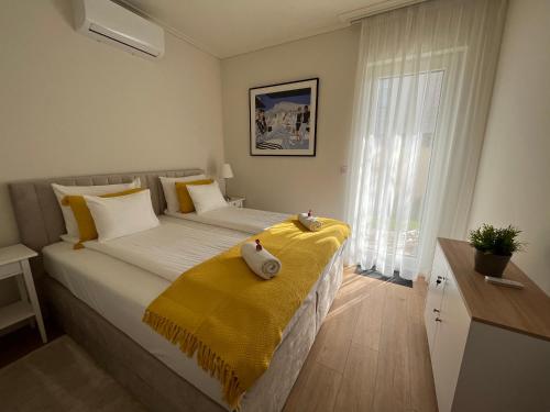 a bedroom with a large bed with a yellow blanket on it at Nature in the City lower storey Bestern in Szeged