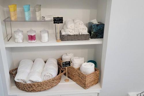 un armario con 2 cestas de toallas y toallas en Cheerful 2-Bedroom Apartment with Smart Home Tech., en Uniondale