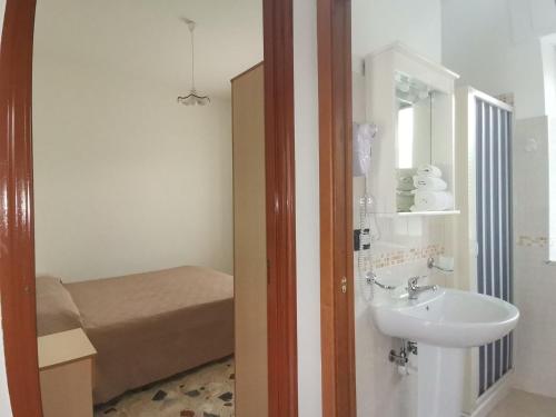 a bathroom with a sink and a bed at Le Zagare Case Vacanza in Cropani