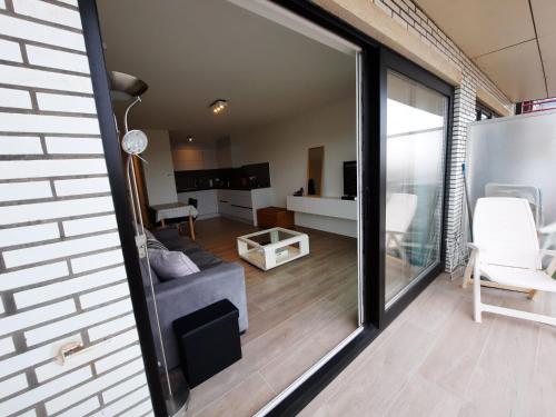 een woonkamer met een bank en een raam bij Premium Holidays - Charming studio Sparrow near the beach of Koksijde in Koksijde