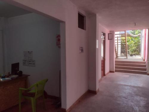 un couloir avec une chaise, une table et une porte dans l'établissement flying monkey hostel, à Nazca