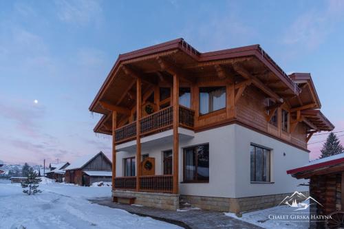 a house in the winter with snow on the ground at Apartments Chalet Girska Hatyna in Vorokhta