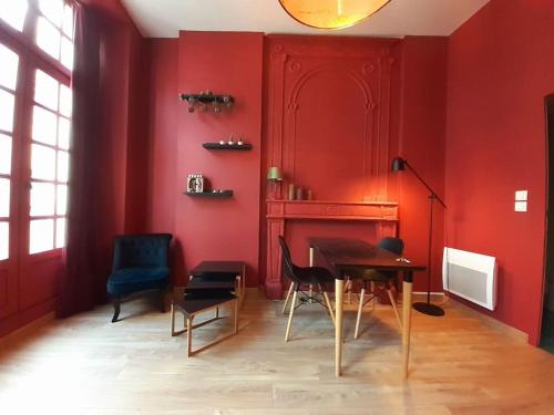 a dining room with red walls and a table and chairs at Le Pillow Rit in Nantes