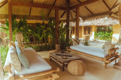 a pavilion with two beds and a coffee table at INARA Siargao in General Luna