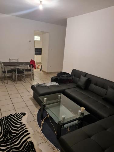 salon z czarną kanapą i stołem w obiekcie Fabuleux t3 refait à neuf avec cour intérieure w mieście Saint-Étienne