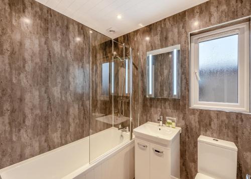 uma casa de banho com um lavatório e um chuveiro. em Hambleton Lakeside Lodges em Poulton le Fylde