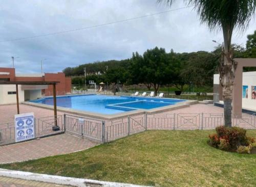 una gran piscina en un patio con una palmera en Departamento amueblado moderno, en Manta