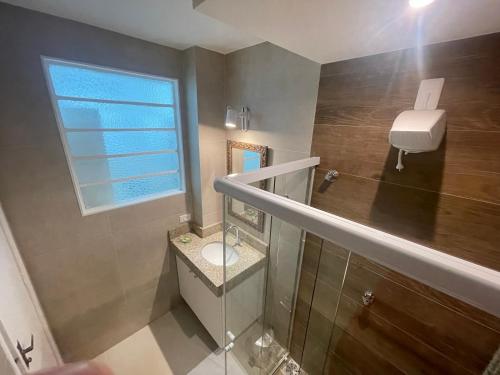 baño pequeño con aseo y ventana en New FLAT 504, en Petrópolis