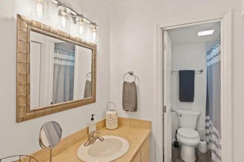 La salle de bains est pourvue d'un lavabo, de toilettes et d'un miroir. dans l'établissement Mountainside Easy Walk to Gondola Updated Condo, à Steamboat Springs