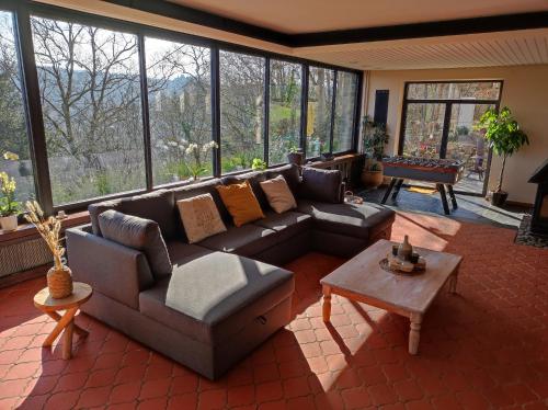 uma sala de estar com um sofá e uma mesa em Villa Viveye em Ferrières