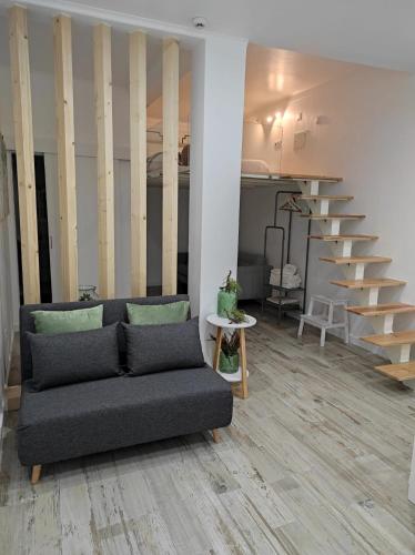 a living room with a couch and a staircase at 7 Trevos Houses B in Santiago do Cacém
