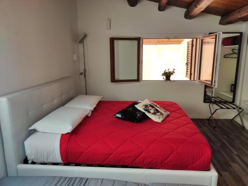 ein rotes Bett in einem Zimmer mit Fenster in der Unterkunft San Francesco Rooms and Apartment with Terrace in Palermo in Palermo