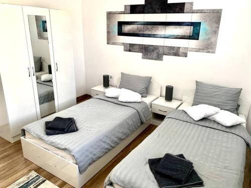 1 Schlafzimmer mit 2 Betten und einem Spiegel in der Unterkunft Asitad DeLuxe Apartments in Ruse