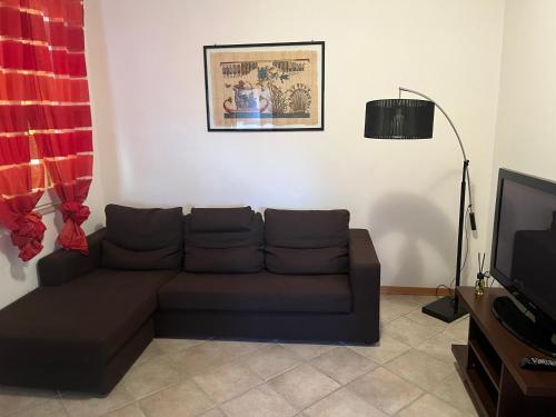 sala de estar con sofá y TV en La Casa del Ciarlatano, en Cerreto di Spoleto