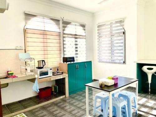 a kitchen with blue cabinets and a table and stools at H Family Banglo Seremban #fit 20pax max #spacious carpark in Seremban