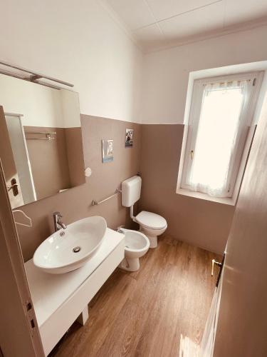 a bathroom with a sink and a toilet and a window at Antica Locanda La Posta in Gaggio Montano
