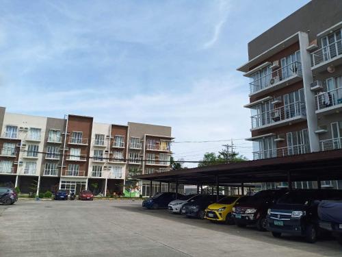 a parking lot with cars parked in front of buildings at Modena Town Square-Walkup Condominium in Minglanilla