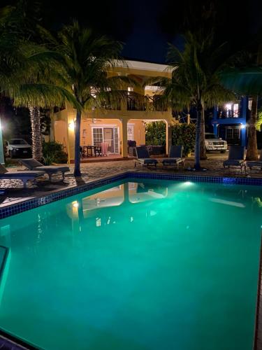 a swimming pool in front of a house at night at Casa Makoshi Bonaire in Kralendijk