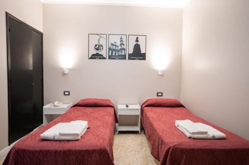 two beds in a room with red sheets and towels at Hotel Marilian in Salta