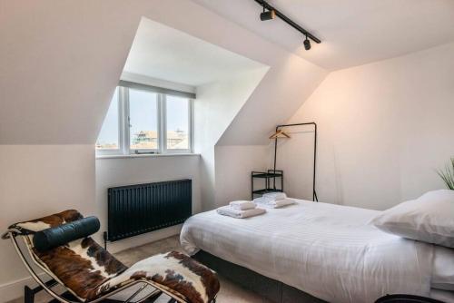 KentにあるSeascape loft - Ramsgate Modern three bedroom apartmentの白いベッドルーム(ベッド1台、椅子付)
